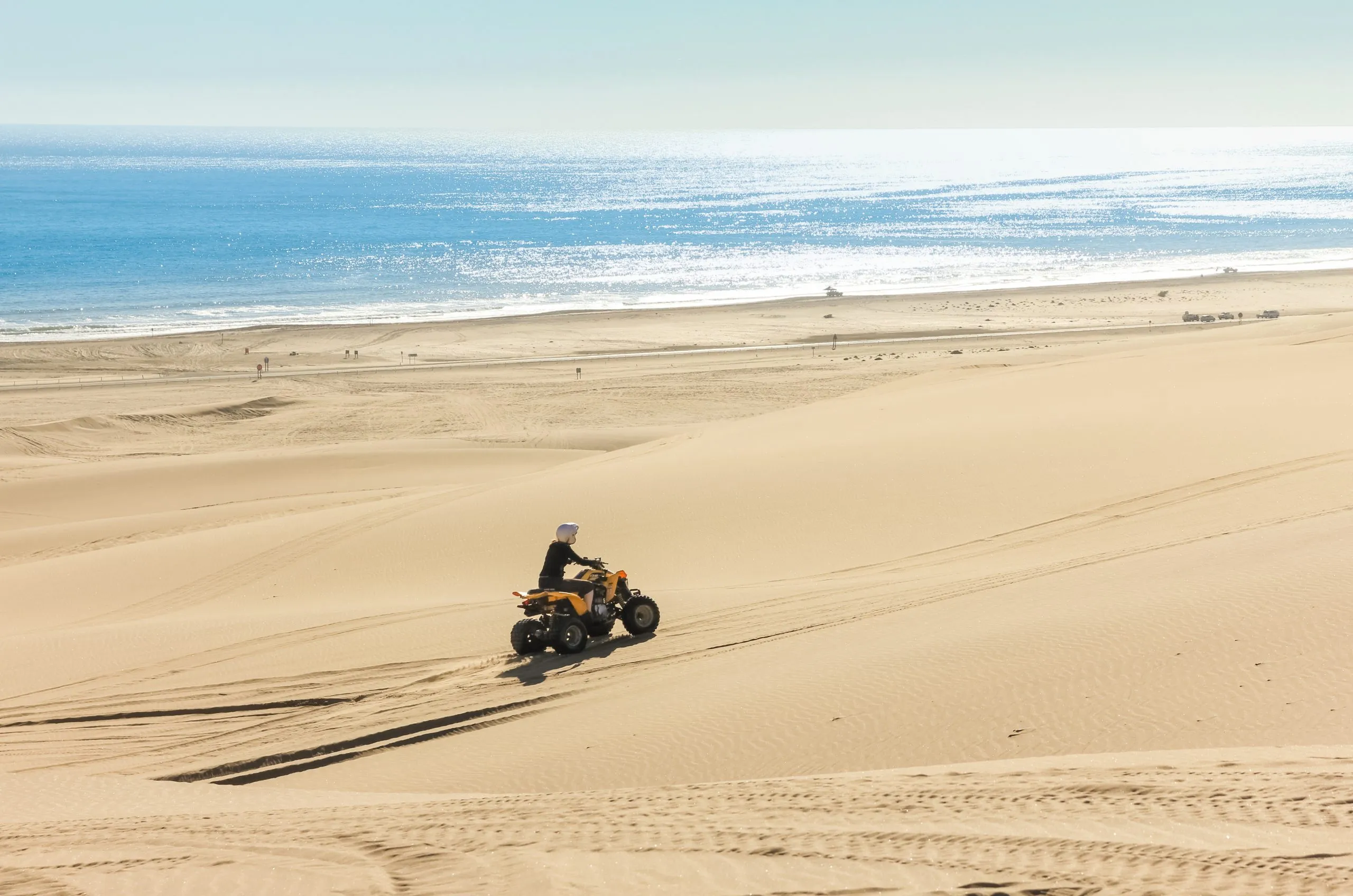Quad driving people - One biker in sand desert dunes at ocean coast beach, Africa, Namibia, Namib, Walvis Bay, Swakopmund.